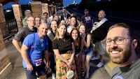a group of people posing for a selfie at a train station