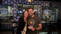 a man and woman posing for a picture in a bar